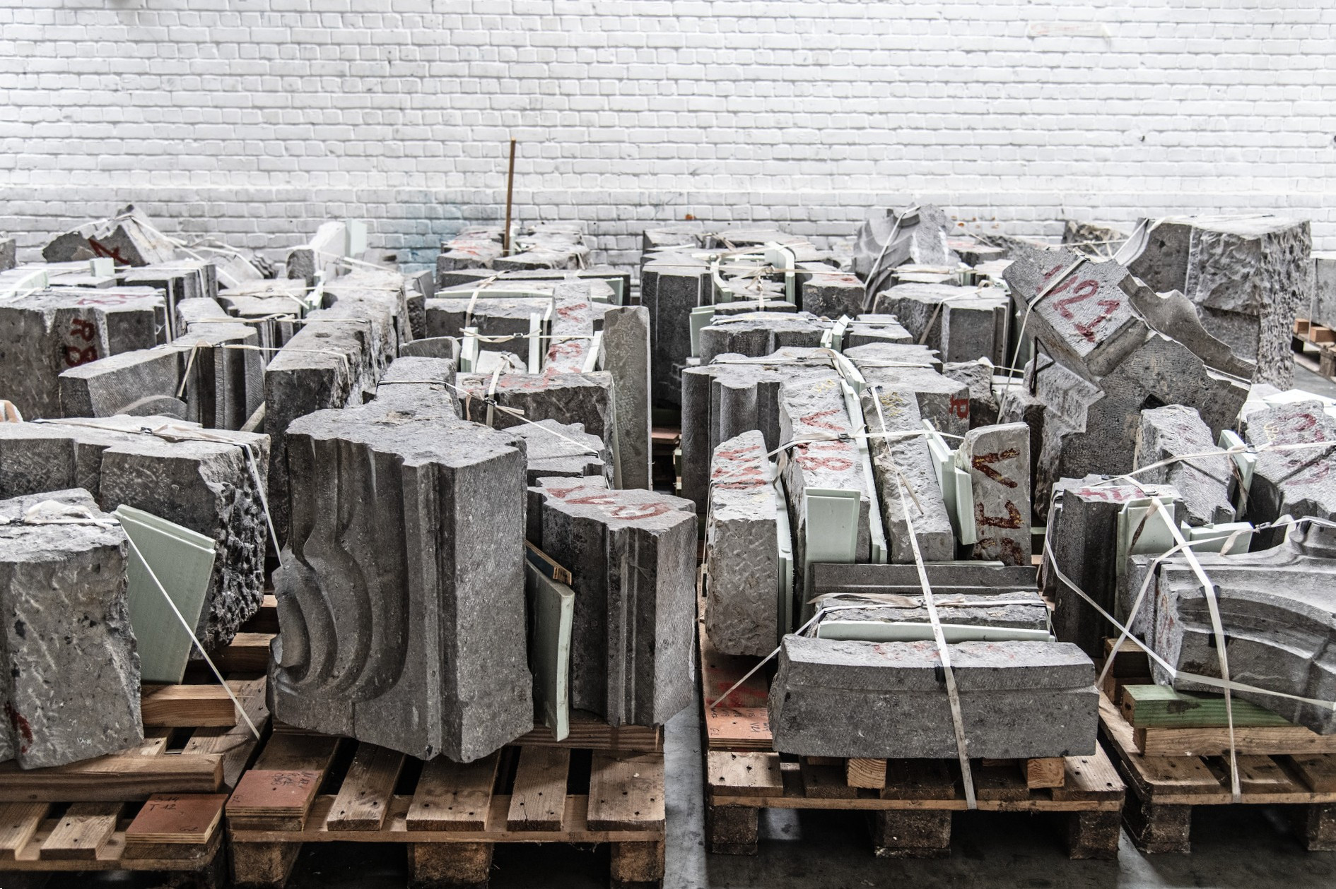De stenen van de gevel Aubecq opgeslagen op pallets vóór de verhuis | A. de Ville de Goyet © urban.brussels